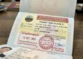 visa du lịch Campuchia (mẫu chữ T) được dán vào hộ chiếu cùng con dấu nhập cảnh